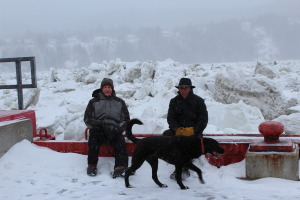 Alan and our friend Don Crockford sitting on top of wharf with ice pack towering over them